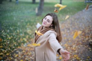 happy woman outside twirling in the park