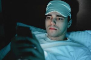 man in bed on phone