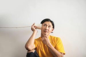 man listening through a cup and string