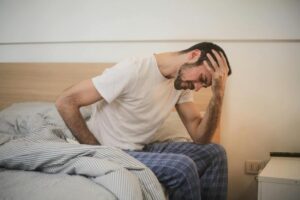 man getting up from bed tired