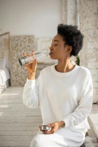 woman drinking out of a water bottle