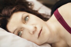 woman laying in bed frightened